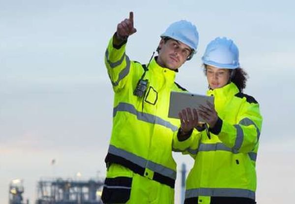 Two Sama Al Ibtikaar engineers reviewing project documentation at a petrochemical plant