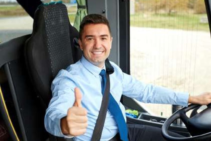Professional bus driver seated at the wheel of a passenger coach