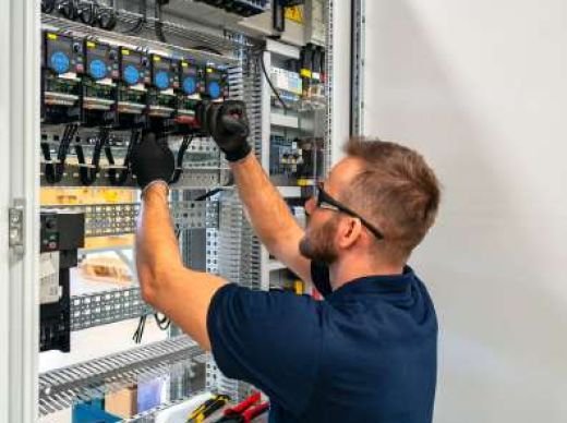 Electrician wiring an industrial control panel