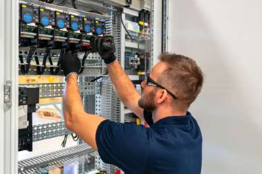 Electrician wiring an industrial control panel