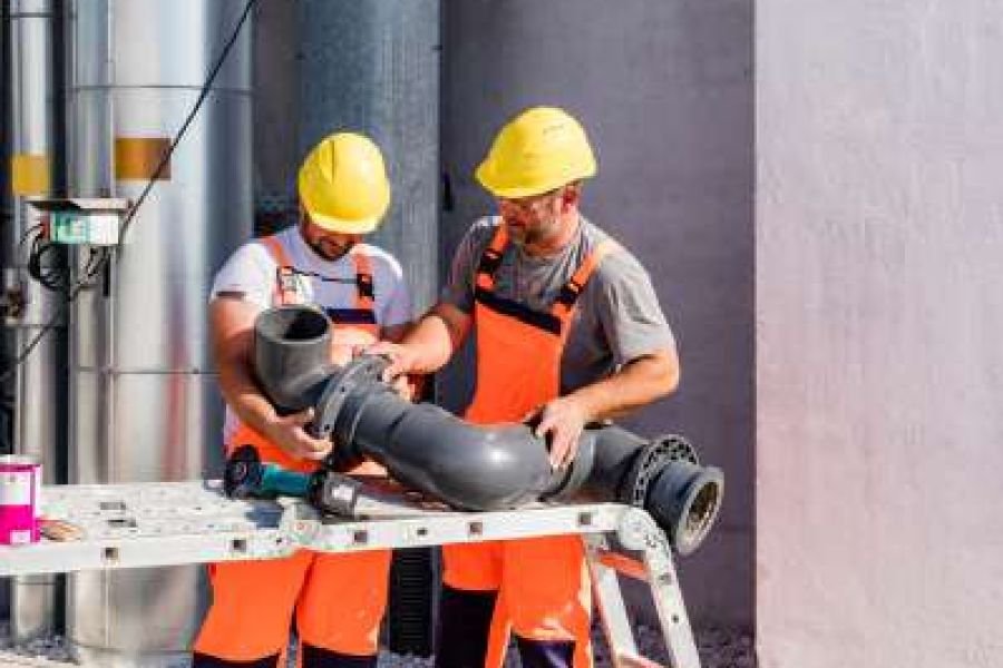 Pipe fitters assembling large-diameter pipework at an industrial facility