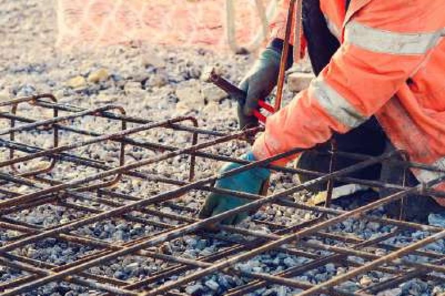 Steel fixer tying reinforcement mesh on a construction site