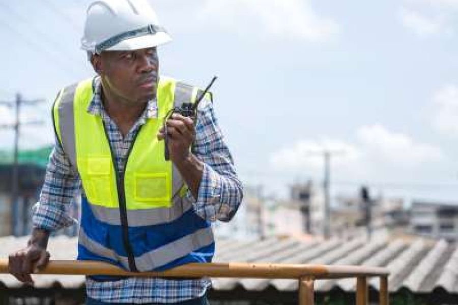 Site supervisor coordinating work by radio on a construction project